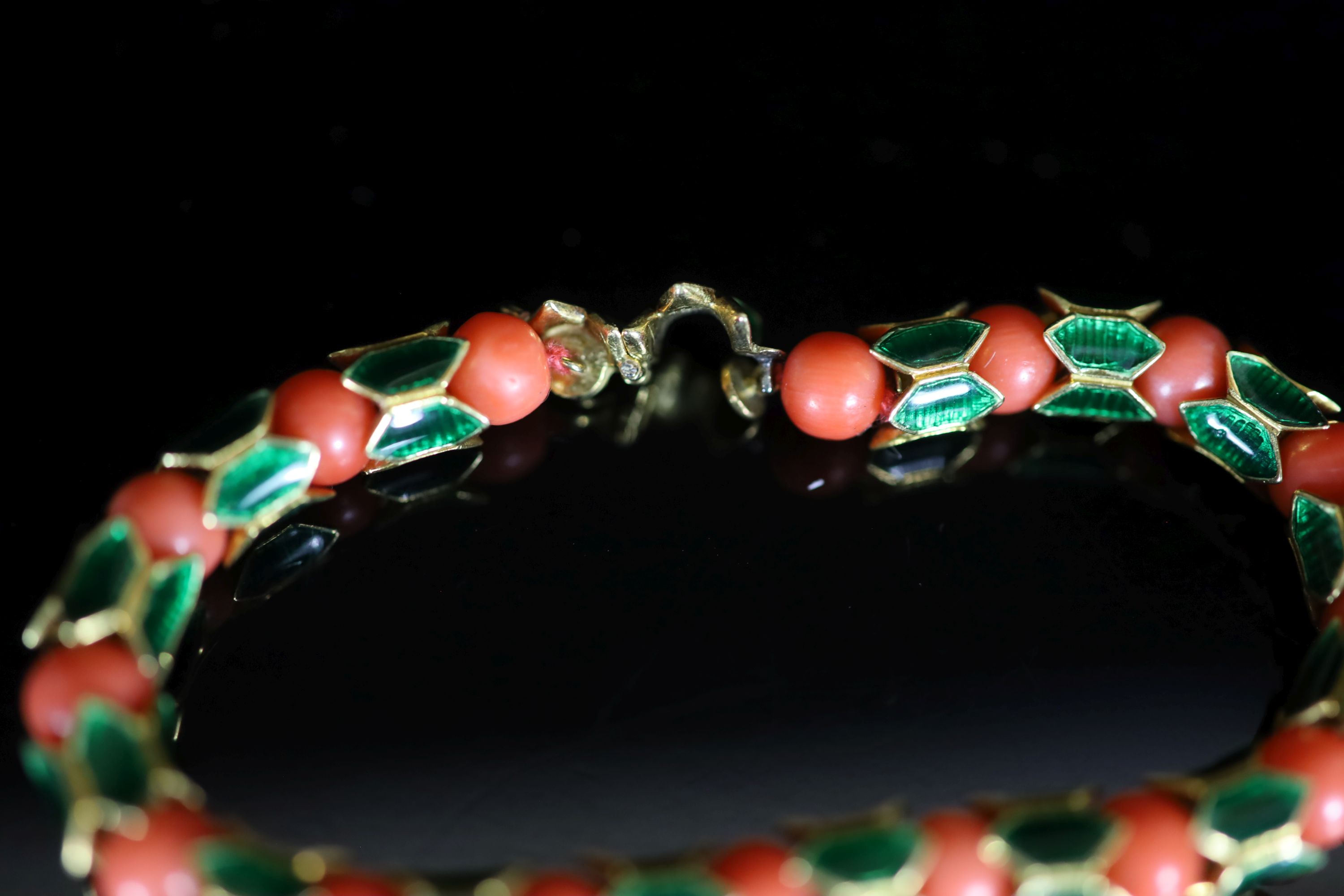 A good 1950's Cartier gold, coral bead and green enamel set articulated bracelet